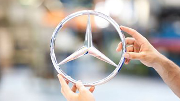 hands holding Mercedes Benz logo